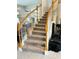 Elegant curved staircase with wood railing and neutral carpeting at 2733 Scarborough Dr, Kissimmee, FL 34744