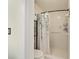 Bright bathroom featuring a shower with a leafy curtain, toilet, and storage rack for towels and toiletries at 4011 Se 47Th Pl, Ocala, FL 34480