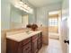 Bathroom featuring wood cabinets, a large mirror, decorative lighting, and tile flooring at 4011 Se 47Th Pl, Ocala, FL 34480