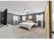 Spacious bedroom with neutral carpet, barn door, and dual windows at 4011 Se 47Th Pl, Ocala, FL 34480