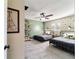 Bedroom showcasing two twin beds, open shelving, geometric wallpaper, a ceiling fan, and neutral carpet at 4011 Se 47Th Pl, Ocala, FL 34480