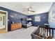 Bedroom with blue walls showcasing a bunk bed, crib, dresser, and carpet flooring at 4011 Se 47Th Pl, Ocala, FL 34480