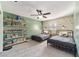 Bright bedroom featuring twin beds, open shelving for toys and books, and a neutral colored carpet at 4011 Se 47Th Pl, Ocala, FL 34480