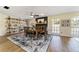Open dining space with rustic table set, brick fireplace, and shelving at 4011 Se 47Th Pl, Ocala, FL 34480
