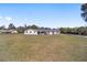Single-story home with neutral paint color, a well-manicured lawn, and lovely landscaping at 4011 Se 47Th Pl, Ocala, FL 34480