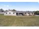 Charming single-story home with white exterior, well-maintained lawn, and inviting front porch with chairs at 4011 Se 47Th Pl, Ocala, FL 34480