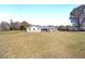 A neutral-colored house with a wide-open lawn and well-placed landscaping on a sunny day at 4011 Se 47Th Pl, Ocala, FL 34480