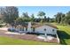 View of the backyard featuring a large patio, firepit, and spacious lawn surrounded by mature trees at 4011 Se 47Th Pl, Ocala, FL 34480