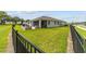 Large backyard with screened patio, grassy area, and black metal fence at 5172 Nw 46Th Lane Rd, Ocala, FL 34482