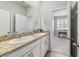 Double vanity bathroom with granite countertop and view of an adjacent home office at 5172 Nw 46Th Lane Rd, Ocala, FL 34482