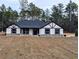 Single-story home with a dark roof and light-colored siding, featuring stone accents at 8193 Sw 127Th Ave, Dunnellon, FL 34432