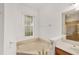 Bathroom features a soaking tub with gold fixtures and vanity with sink at 8463 Sw 84Th Loop, Ocala, FL 34481