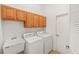 Functional laundry room with overhead cabinets, a utility sink, washer, and dryer offering convenience and storage at 8463 Sw 84Th Loop, Ocala, FL 34481