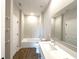 Bright bathroom featuring modern vanity with large mirror, tub and shower combo, and tile flooring at 10107 Sw 41St Ave, Ocala, FL 34476