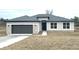 Single-story home featuring a gray roof, two-car garage, and stone veneer accents at 10131 Sw 41St Ave, Ocala, FL 34476