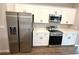 Modern kitchen with stainless steel refrigerator and appliances, paired with white cabinets at 10131 Sw 41St Ave, Ocala, FL 34476