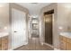 Ensuite bathroom featuring a walk-in shower, double vanities, and hallway with natural light at the end at 2215 Se 24Th Ave, Ocala, FL 34471