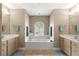 Bright bathroom featuring dual vanities, large soaking tub under an arched window, and tile floors at 2215 Se 24Th Ave, Ocala, FL 34471