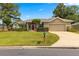 Inviting single-story home with a well-manicured lawn, attached garage, and charming red front door at 2215 Se 24Th Ave, Ocala, FL 34471