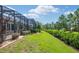 Beautiful backyard with manicured lawn, mature trees, and screened lanai for outdoor living at 8445 Sw 93Rd Cir, Ocala, FL 34481