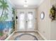 Bright foyer with double glass doors, tile flooring, and a whimsical mural for a beachy vibe at 8445 Sw 93Rd Cir, Ocala, FL 34481