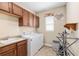 Bright laundry room with white washer and dryer, built in cabinets, and utility sink offers functionality at 8445 Sw 93Rd Cir, Ocala, FL 34481