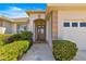 Close up of the front entrance of the home with decorative landscaping and charming architectural features at 9882 Sw 89Th Lane Rd, Ocala, FL 34481
