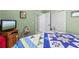Cozy bedroom with colorful quilt, television, and closet space at 12333 Se 177Th Loop, Summerfield, FL 34491