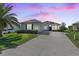 Charming single-story home with a well-manicured lawn, a long driveway and lush landscaping at 12333 Se 177Th Loop, Summerfield, FL 34491
