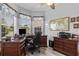 Inviting home office with wood desk, grey floors, natural light and a ceiling fan at 12333 Se 177Th Loop, Summerfield, FL 34491