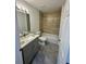 Bathroom with updated vanity, attractive floor tiles, and a shower-tub combination with beige tile at 3 Dogwood Trl, Ocala, FL 34472