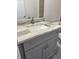 Close-up on bathroom vanity featuring a light granite counter, grey cabinets, and modern hardware at 3 Dogwood Trl, Ocala, FL 34472