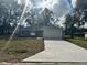Charming one-story home with a fresh concrete driveway and attached two car garage at 3 Dogwood Trl, Ocala, FL 34472