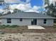 Back of home featuring sliding glass doors, a concrete pad, and large windows at 3 Dogwood Trl, Ocala, FL 34472