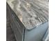 Close up view of a gray kitchen island with light, marbled stone countertops at 3 Dogwood Trl, Ocala, FL 34472