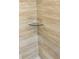 Shower with shower head, shower handle, and corner glass shelf with attractive beige tile at 3 Dogwood Trl, Ocala, FL 34472