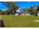 Single-story house on a grassy lot with trees and a clear sky at 3339 Se 141St Pl, Summerfield, FL 34491