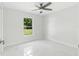 Bright bedroom with large window, ceiling fan, and tiled floors at 3339 Se 141St Pl, Summerfield, FL 34491