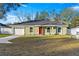 Newly constructed home with green exterior, red door, and attached garage at 3339 Se 141St Pl, Summerfield, FL 34491