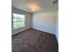 A well-lit bedroom with a large window and neutral carpeting at 6272 Sw 155 Street Rd, Ocala, FL 34473