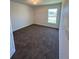 A cozy bedroom with a large window and neutral carpeting at 6272 Sw 155 Street Rd, Ocala, FL 34473