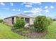 View of rear exterior featuring green lawn, landscaping, shrubs and covered porch at 7709 Sw 86Th Ct, Ocala, FL 34481