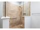 Walk-in shower with light stone tile, glass surround, shower head, grab bar and convenient corner seat at 7709 Sw 86Th Ct, Ocala, FL 34481