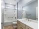 Bathroom features a shower-tub combo, neutral-tone tile flooring, and white vanity with a large mirror at 7709 Sw 86Th Ct, Ocala, FL 34481