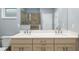 Neutral-toned bathroom with double vanity, quartz counters, large mirror and a glass-enclosed shower with a grab bar at 7709 Sw 86Th Ct, Ocala, FL 34481