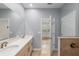 Open bathroom with double vanity, large mirror, and walk-in shower with access to the bedroom at 7709 Sw 86Th Ct, Ocala, FL 34481