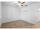 Bright bedroom with a ceiling fan, neutral tile flooring, and a double-door closet for easy storage at 7709 Sw 86Th Ct, Ocala, FL 34481