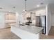 Kitchen boasting an oversized island with granite countertops, stainless steel appliances, and tile backsplash at 7709 Sw 86Th Ct, Ocala, FL 34481