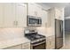 Elegant kitchen showcasing stainless steel appliances, granite countertops, and stylish tile backsplash at 7709 Sw 86Th Ct, Ocala, FL 34481