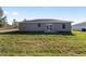 Exterior view of the home showcasing a sliding glass door leading to a spacious, grassy backyard at 15390 Sw 10 Pl, Ocala, FL 34481